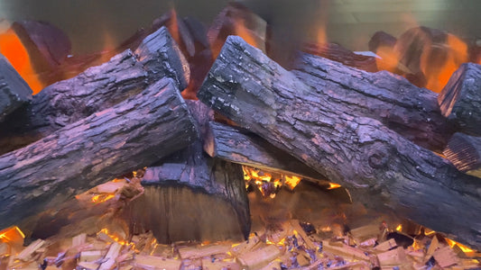 Close-up of burning wood logs in a fireplace with glowing embers.