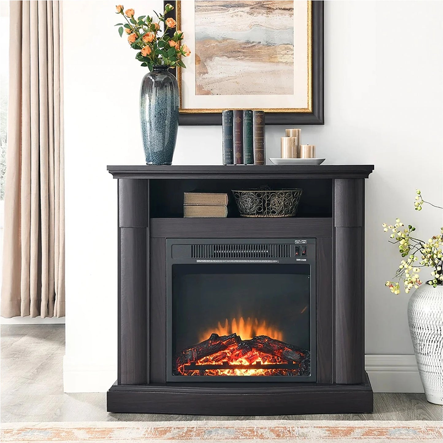 Black electric fireplace with flames on a wooden stand in a room with decor elements.