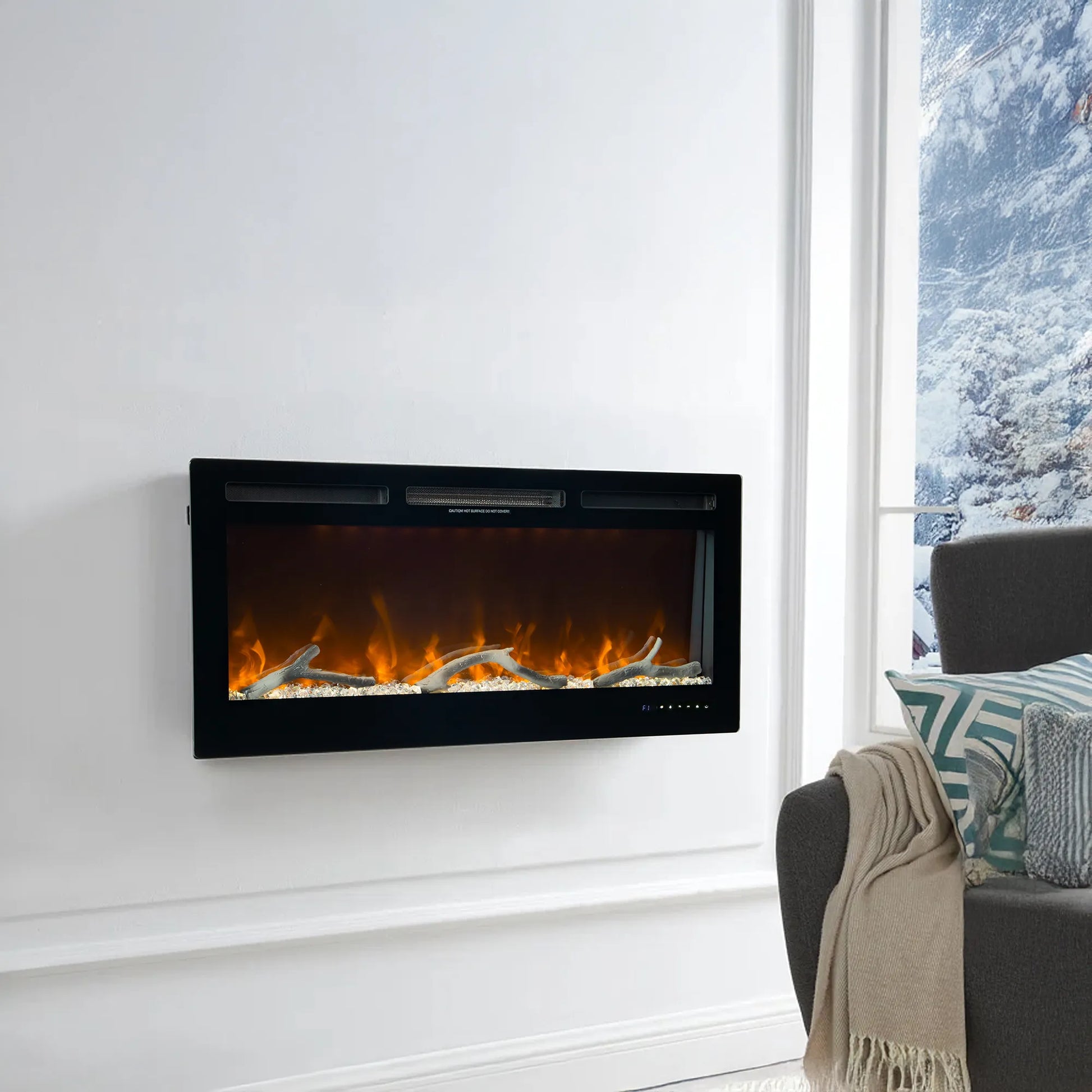 Modern electric fireplace mounted on a white wall with a gray sofa and decorative pillows in the foreground.