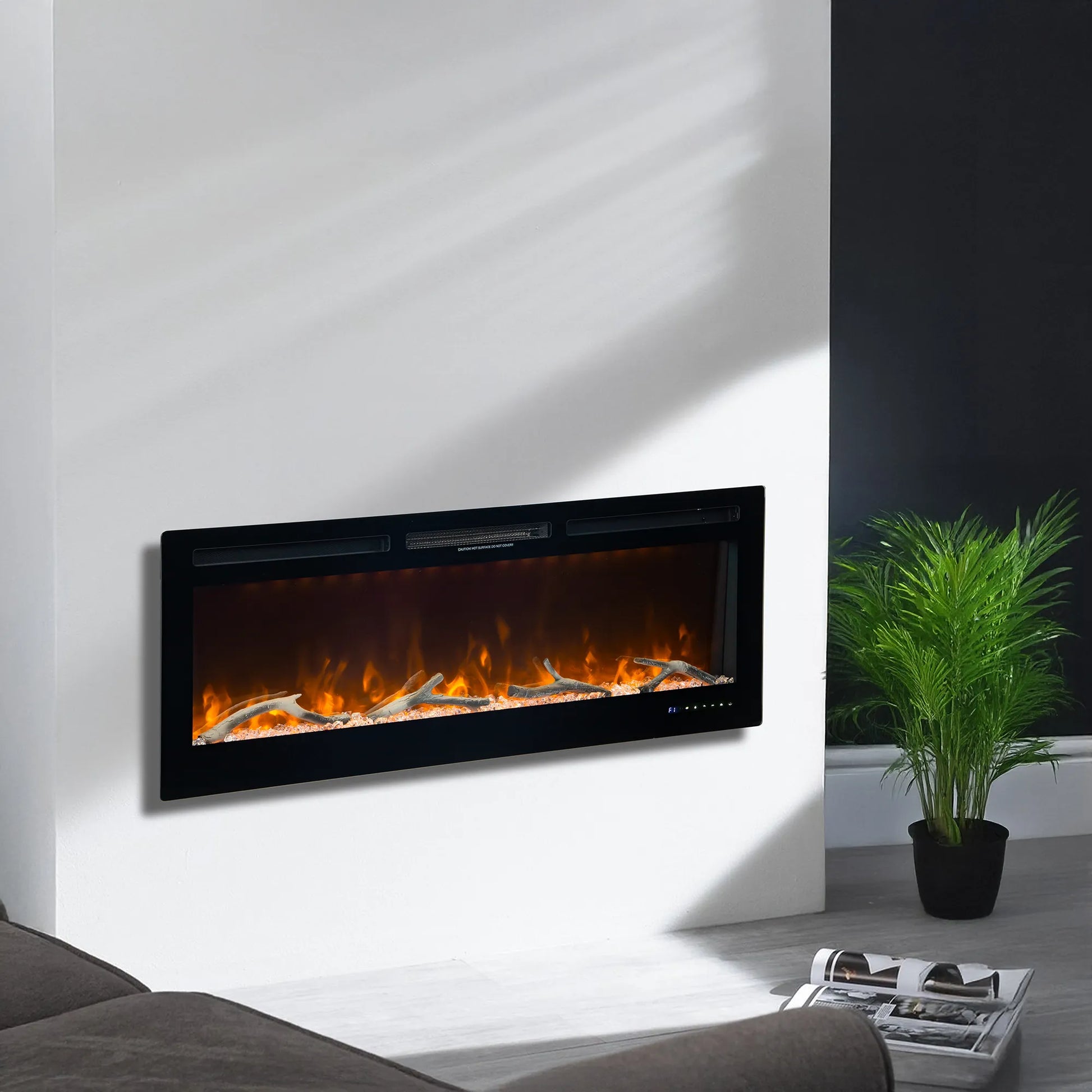 Modern electric fireplace mounted on a white wall with a plant to the right.