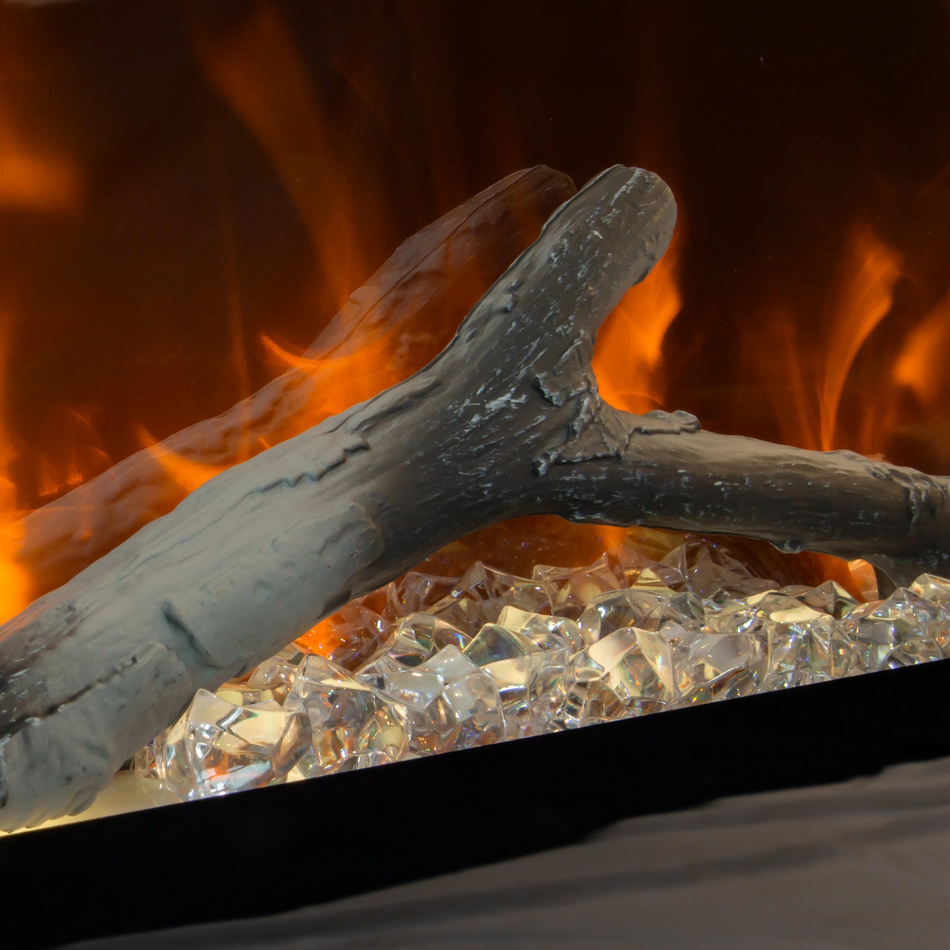 Close-up of a burning log with flames and glowing embers in a fireplace.