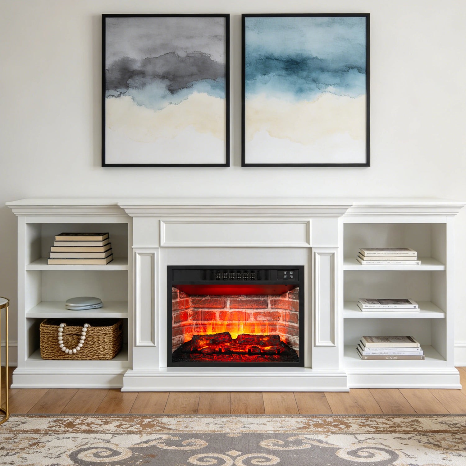 A white built-in electric fireplace with a brick surround and glowing faux logs, styled in a bright living room with open shelving on both sides and two framed abstract wall art prints above.