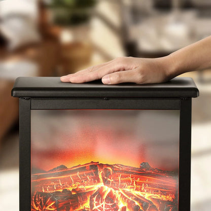 Hand resting on a black box with a fiery design, resembling a fireplace, against a blurred indoor background.